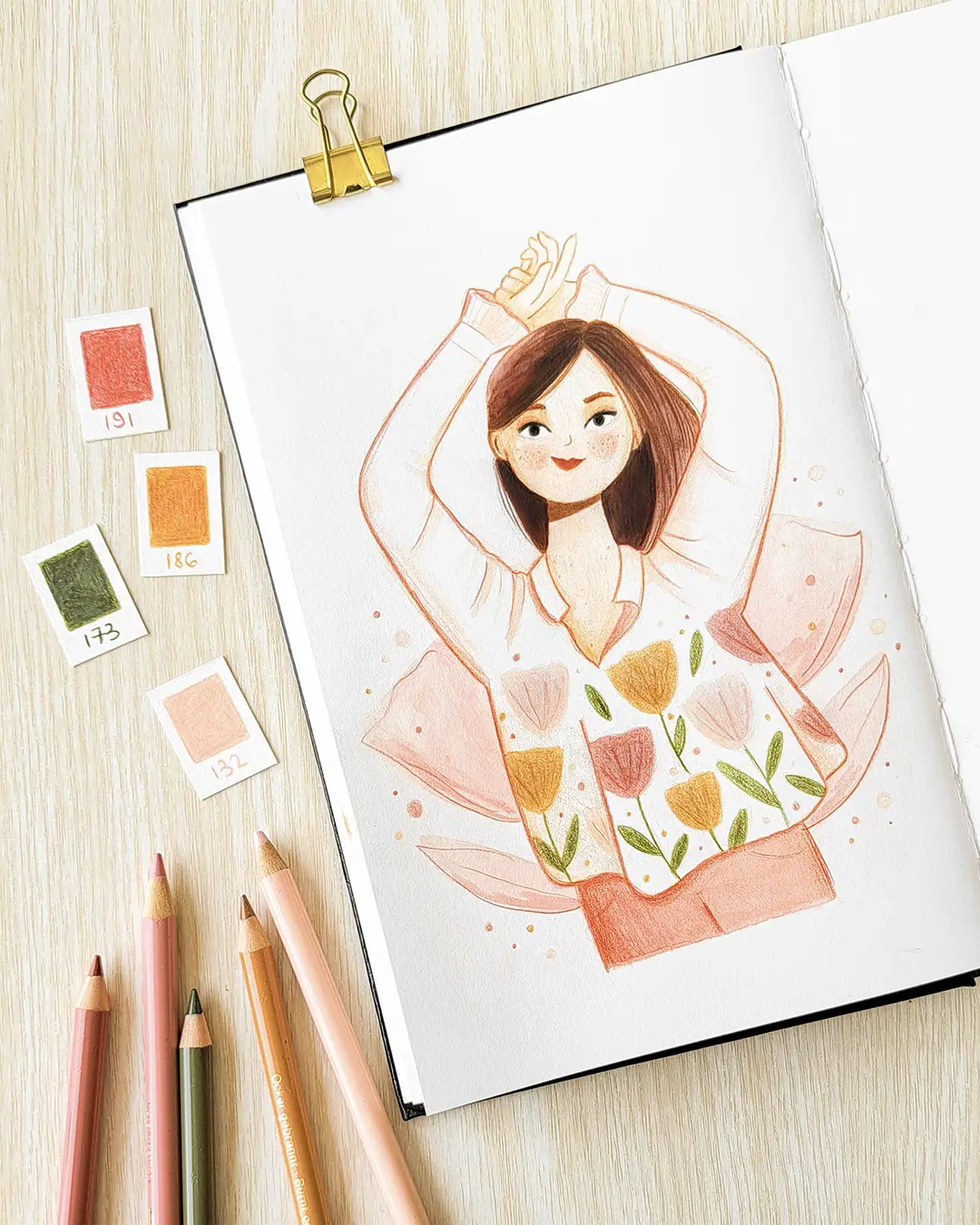 Page de carnet de croquis avec l'illustration d'une femme vêtue d'une blouse à fleurs, dans un décor floral.