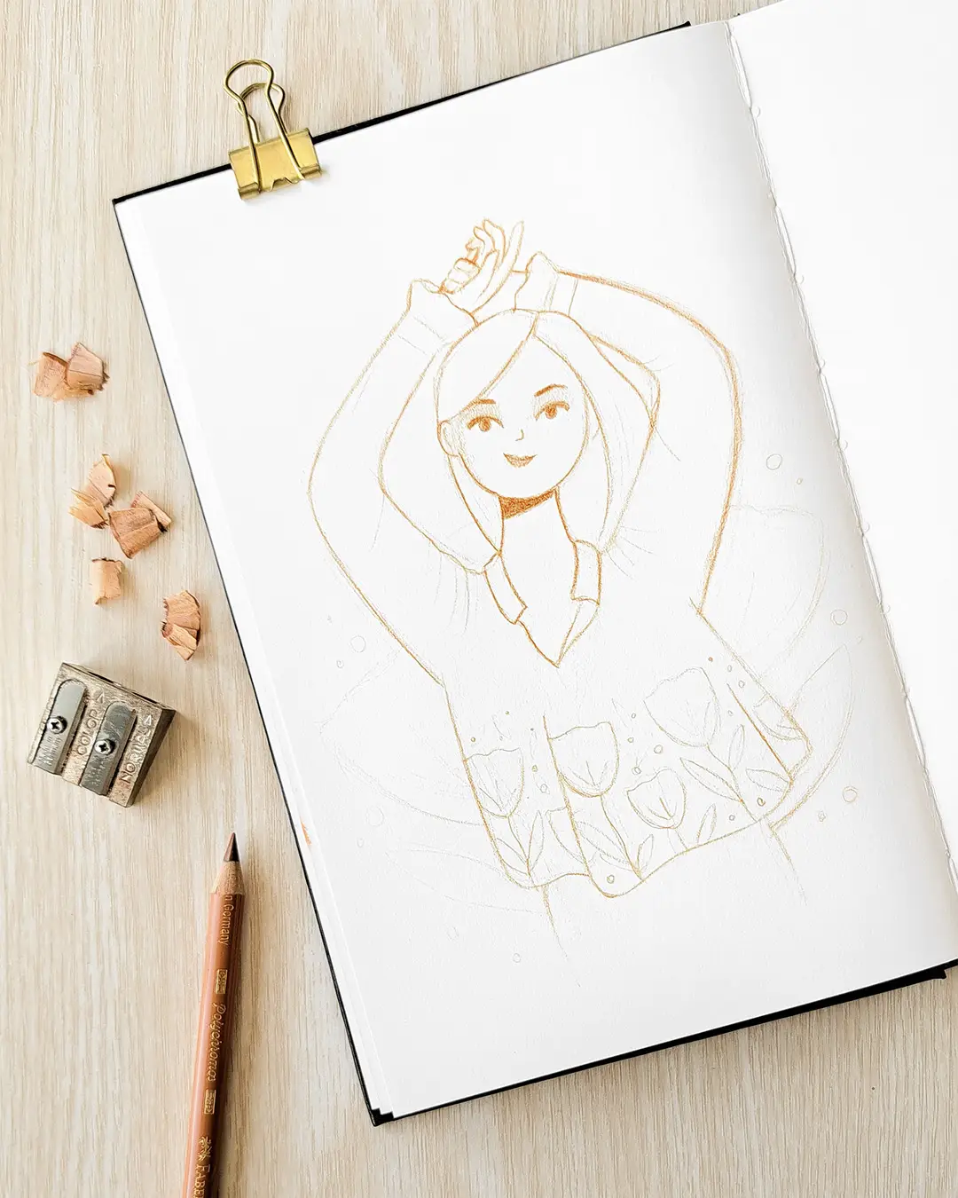 Page de carnet de croquis avec l'esquisse d'une femme vêtue d'une blouse à fleurs.