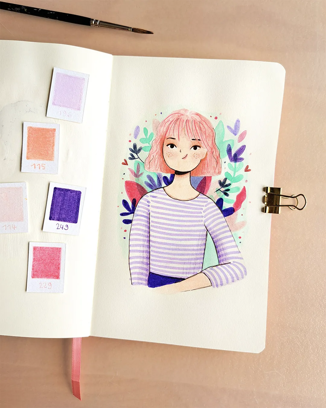 Page de carnet de croquis avec l'illustration d'une femme aux cheveux roses portant une marinière violette, avec des petites feuilles colorées autour.