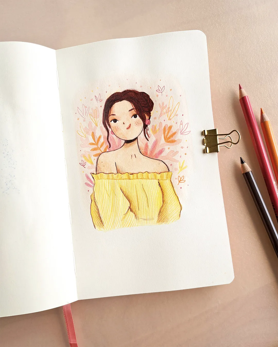 Page de carnet de croquis avec l'illustration d'une femme avec une blouse jaune à rayures portée sous les épaules, dans un décor floral.
