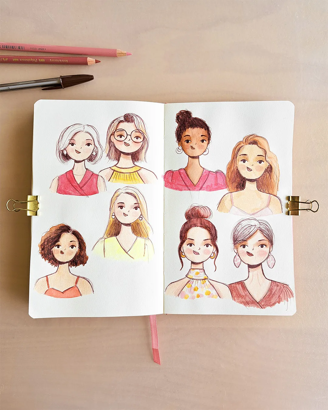 Pages de carnet de croquis avec différentes illustrations de portraits de femmes.