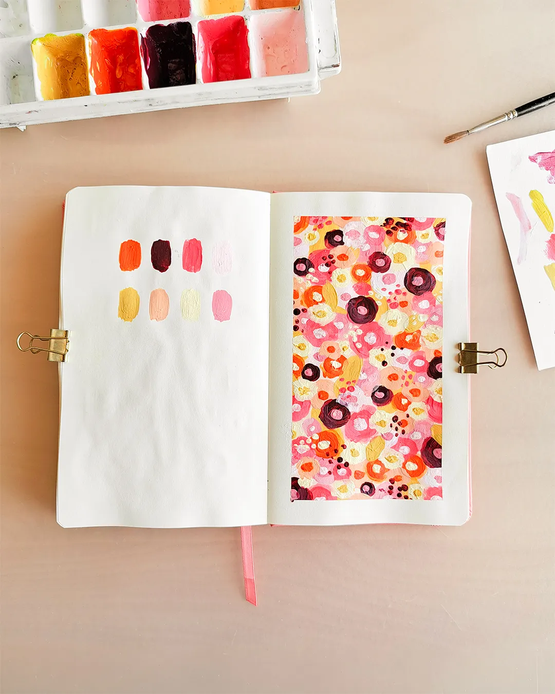 Page de carnet de croquis avec l'illustration d'un motif floral réalisé à l'acrylique, dans une palette de couleurs chaudes.